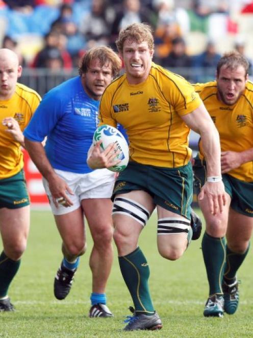 Australia's David Pocock runs with the ball during his team's Rugby World Cup Pool C match...
