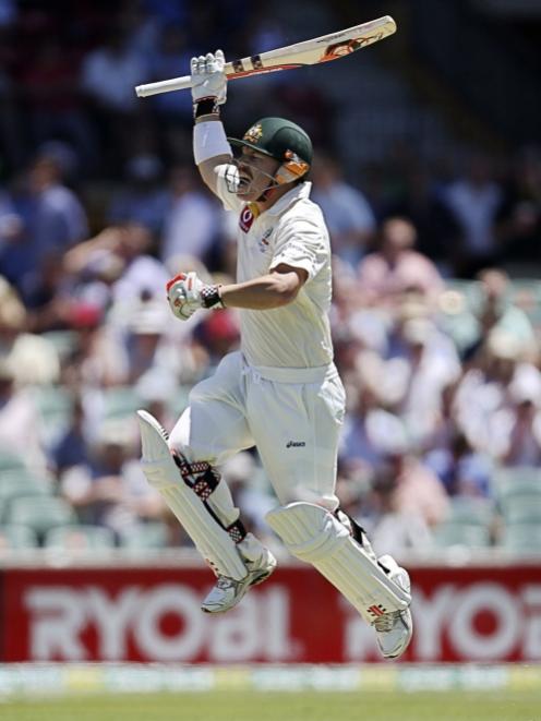 Australia's David Warner celebrates scoring a century during their second cricket test match...