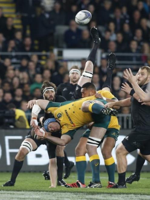 Australia's James Horwill (blue headgear) falls after failing to take a kick-off ball against the...