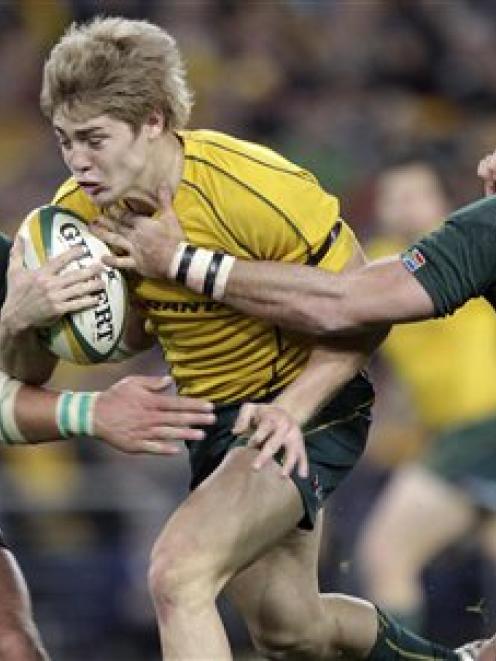 Australia's James O'Connor tries to break the tackles of South Africa's Werner Kruger, left, and...