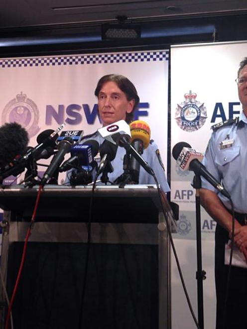 Australian Federal Police Deputy Commissioner Michael Phelan (R) listens as New South Wales...