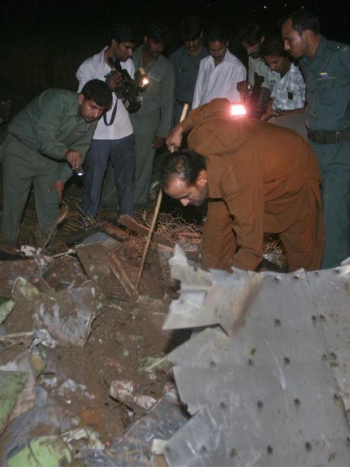 Aviation officials go through the wreckage of a Boeing 737 airliner which crashed in Islamabad.