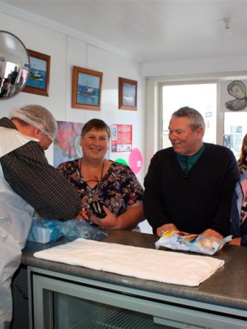 Barnes Oysters manager Graeme Wright serves Joan Black (left), who drove from Gore for her first...