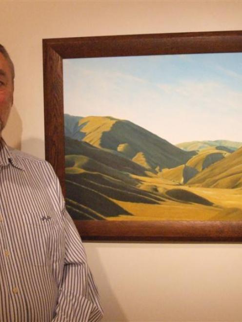 Barry Mackenzie with a painting of the Lindis Pass which is part of his exhibition at the...