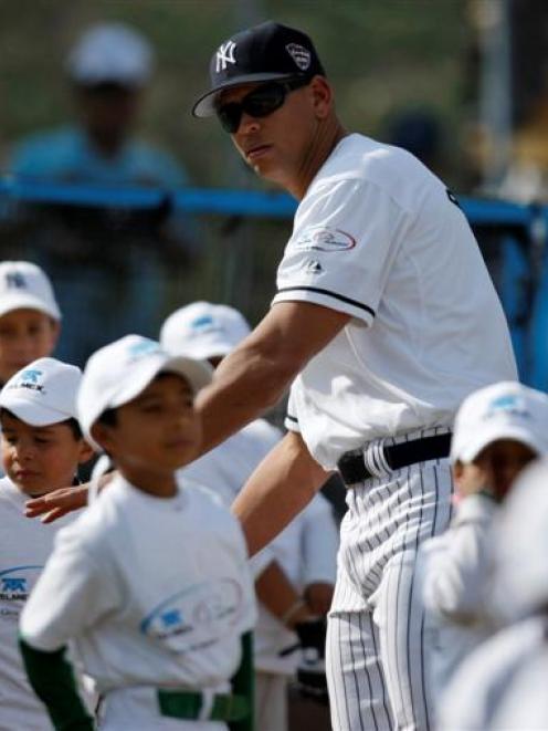 Baseball star Alex Rodriguez, of the New York Yankees, talks to children during a baseball clinic...
