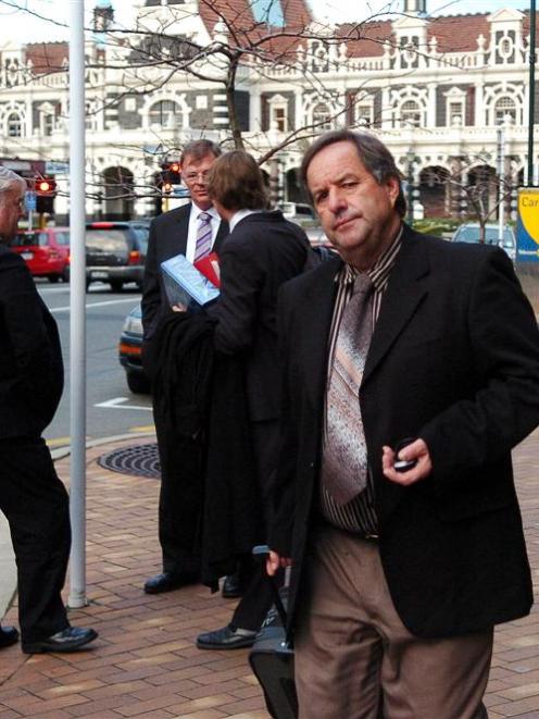 Basil Walker passes (from left) Otago Regional Council director of corporate services Wayne Scott...