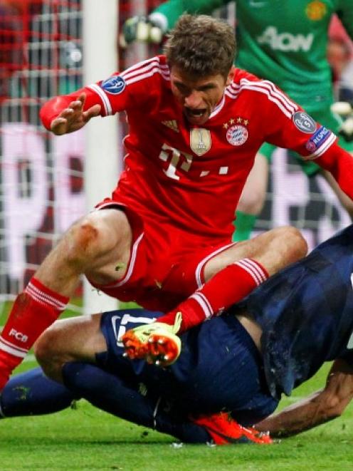 Bayern Munich's Thomas Mueller (L) challenges Manchester United's Nemanja Vidic. REUTERS/Michaela...