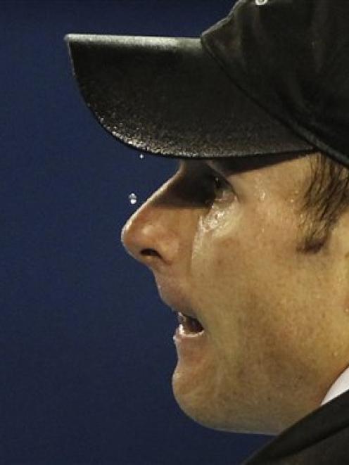 Beads of sweat drop from the cap of Andy Roddick of the US as he prepares to serve to Switzerland...