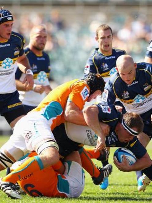 Ben Alexander of the Brumbies is chopped down by the Cheetahs' defence.  (Photo by Cameron...