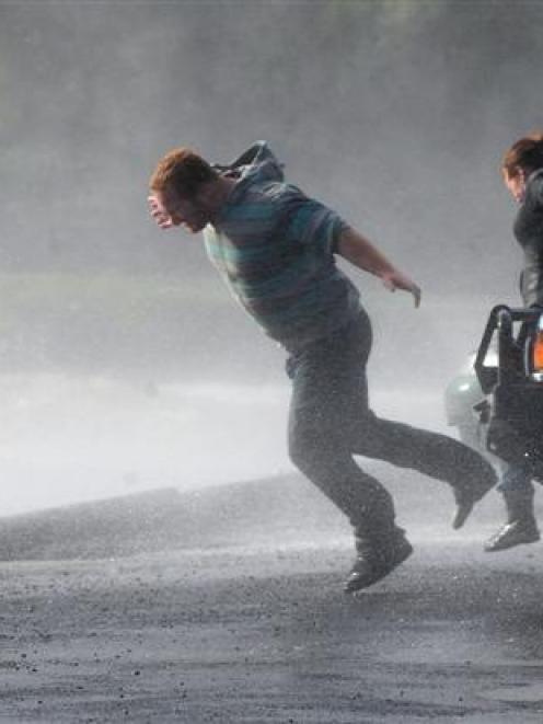 Ben and Erin Fenemore, of Dunedin, are nearly knocked off their feet by a wind gust at Macandrew...