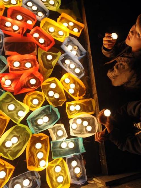 Ben Pinfold, top, and Jesse Milligan (both 12) admire candles lit in Dunedin's Octagon as a part...