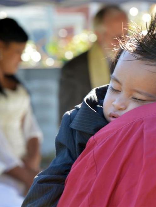 Benjamin Paulo sleeps on a guest's shoulder during the marriage ceremony of his parents, Jesse...