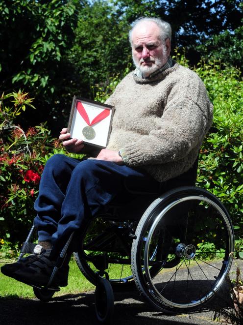 Former paralympian athlete Bill Lean with his 1976 gold medal. Photo by Craig Baxter.