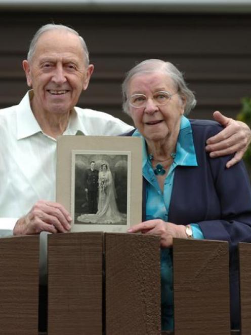 Bill and Iris Watts, at their Woodhaugh St home yesterday, hold a photo of their 1943 wedding....