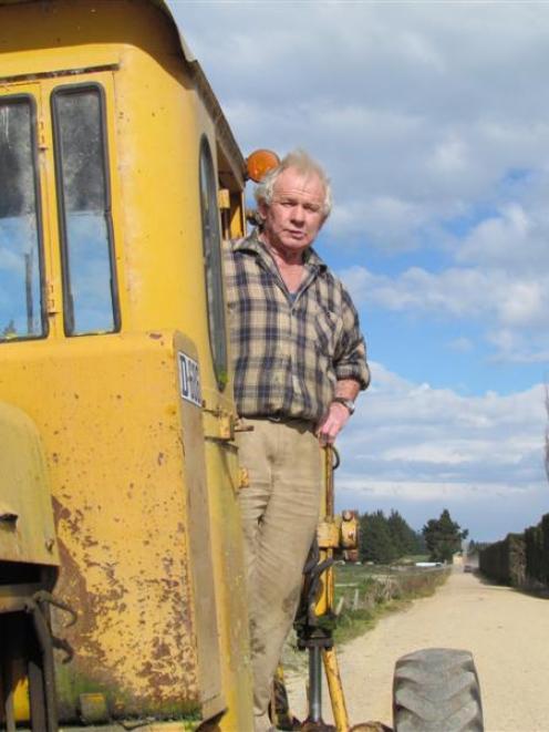 Bill Pile prepares to inspect his handiwork after fixing potholes on Steward Rd with his own...