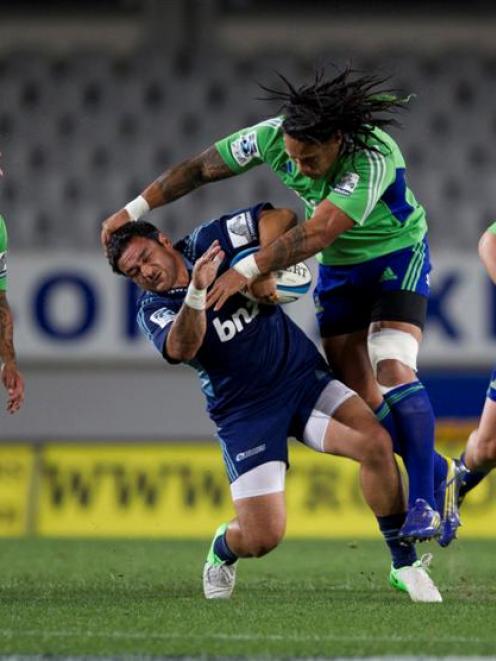 Blues halfback Piri Weepu is hit in an illegal tackle by Highlanders second five-eighth Ma'a Nonu...