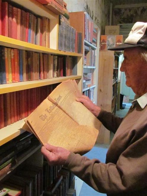Bob Watherston reads a 1905 copy of the Lyttelton Times, which was found in the Kurow book...