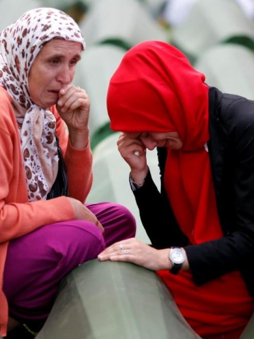 Bosnian Muslim women cry near the coffin of a relative, one of the 175 coffins of newly...