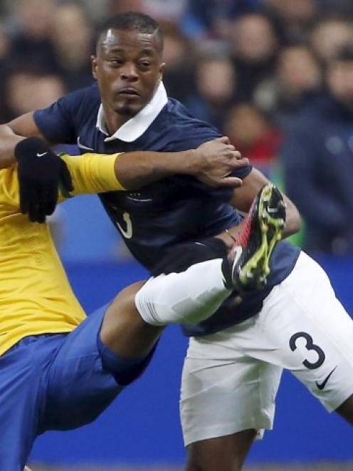 Brazil's Douglas Costa (L) fights for the ball with France's Patrice Evra. REUTERS/Charles Platiau