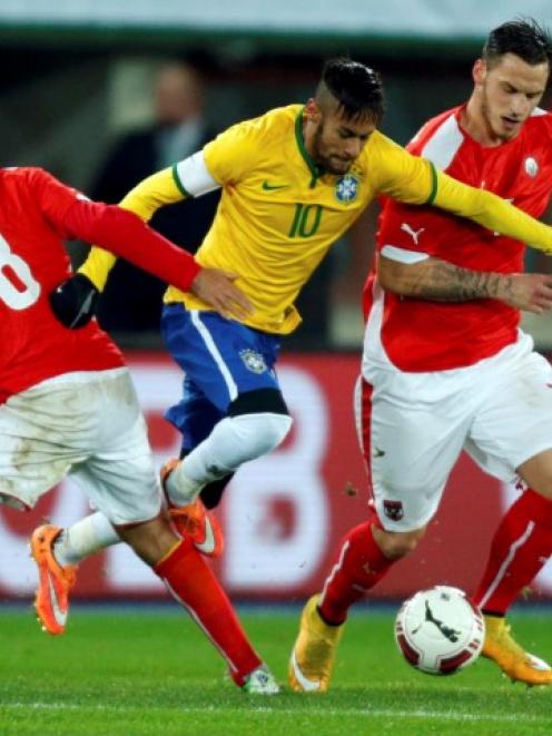 Brazil's Neymar (C) tries to find a way through the Austrian defence. REUTERS/Heinz-Peter Bader