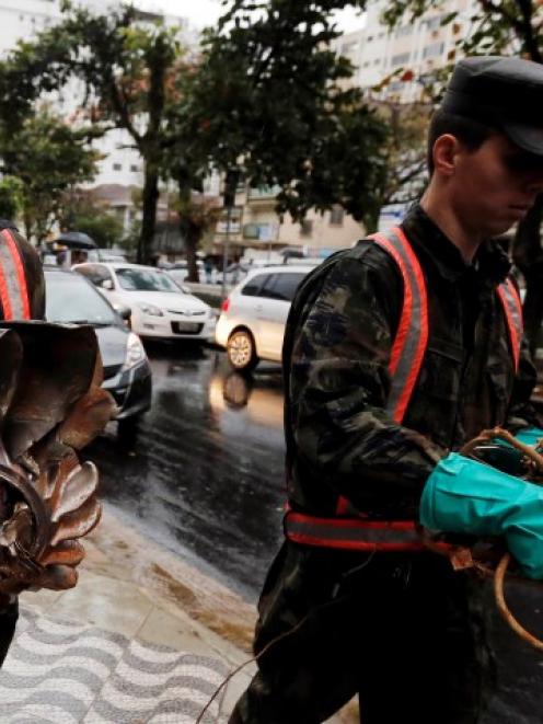 Brazilian air force members carry parts of the crashed private jet which was carrying candidate...