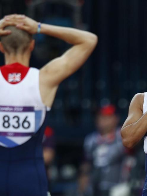 Britain's Adam Gemili reacts with teammate Daniel Talbot after they were disqualified in their...