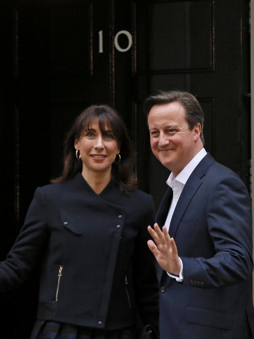 Britain's Prime Minister David Cameron and his wife Samantha wave as they arrive at Number 10...