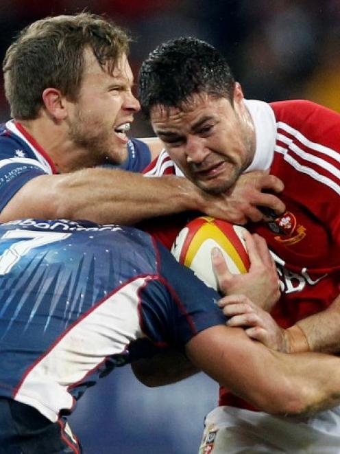 British and Irish Lions player Bradley Barritt (R) is tackled by Lachlan Mitchell (L) and Scott...