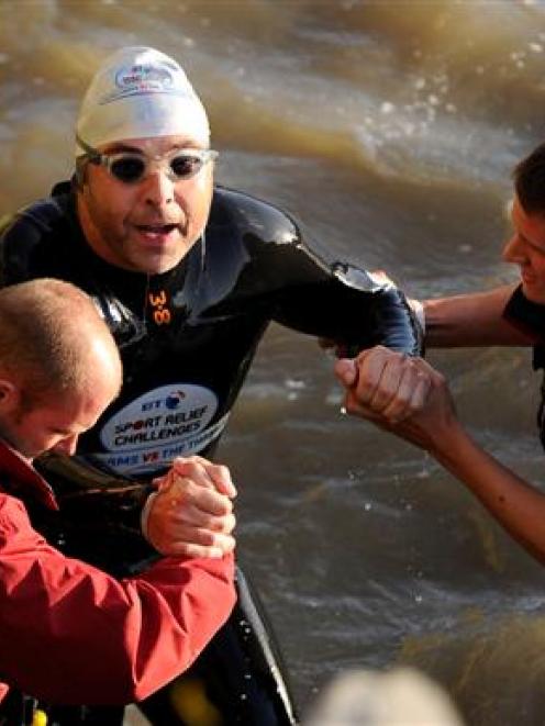 British comedian David Walliams is helped out of the River Thames after his charity swim.  ...