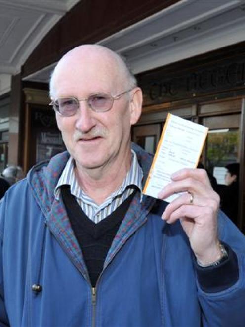 Bruce Marshall, of Dunedin, flashes his reduced price Elton John concert tickets outside the...