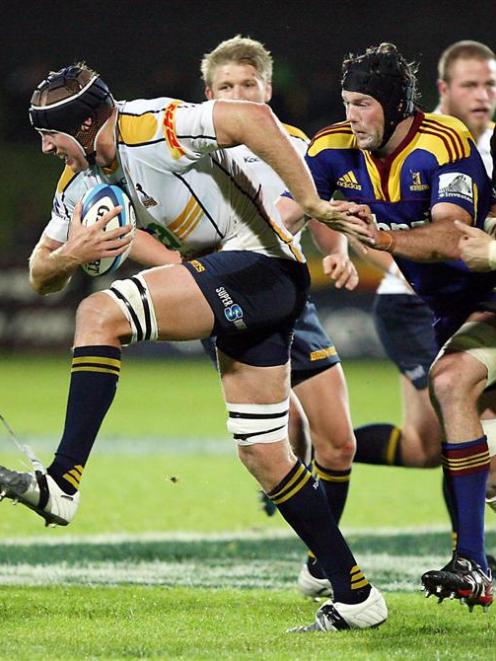 Brumbies lock Ben Hand tries to step his way out of trouble, despite the attentions of...