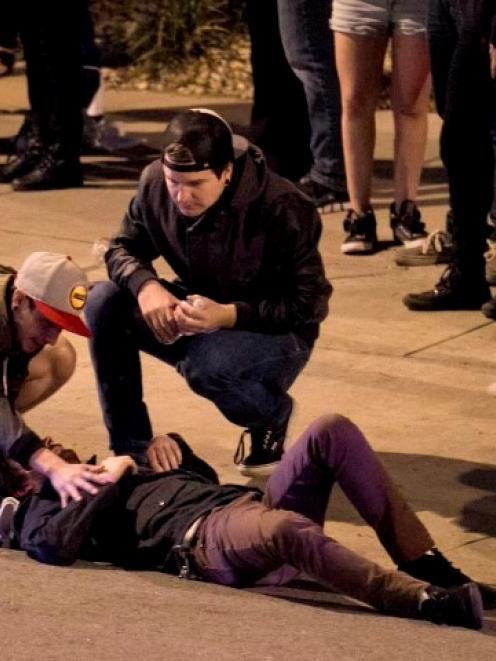 Bystanders tend to a man who was struck by a vehicle during the SXSW festival in downtown Austin...