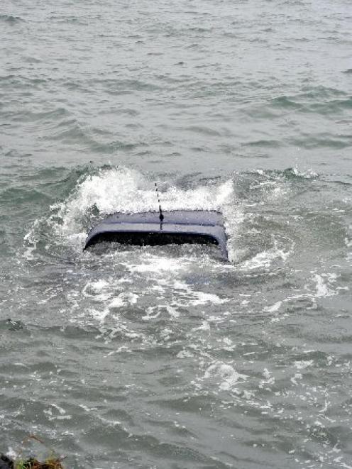A car bobs in Otago Harbour after its driver lost control and slid into the waters off Portobello...