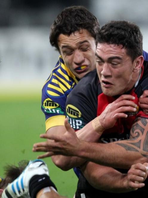 Canterbury's Codie Taylor offloads in the tackle of Otago's Lee Allan during their round four ITM...