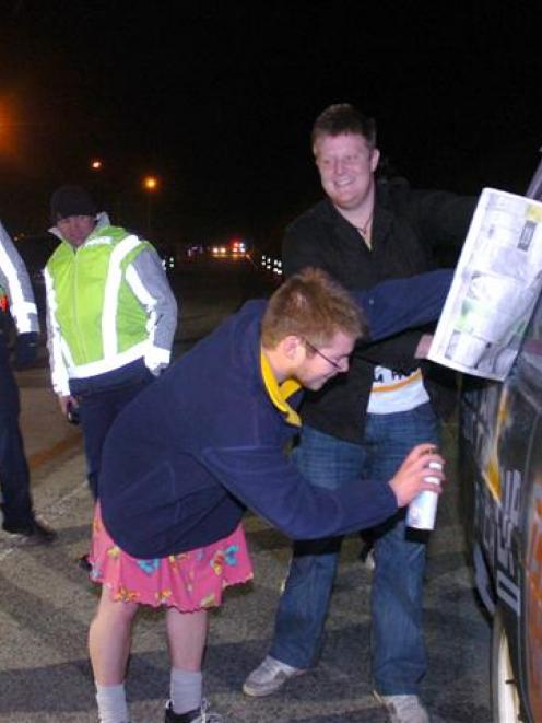 Canterbury student Chris Pennington paints over offensive material at a Dunedin checkpoint as...