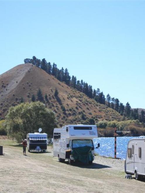 Caravans and camping vehicles park on the shore of Lake Dunstan at Lowburn, near Cromwell. Photo...