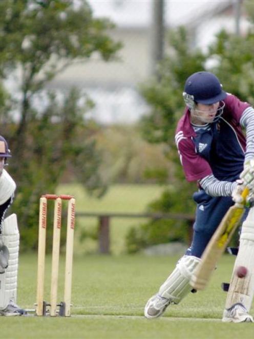Carisbrook-Dunedin opening batsman James Hogg prods forward as Albion wicketkeeper Shaun Haig...