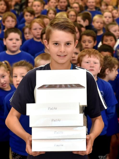 Carisbrook School pupil Noah Scott (13) with some of the iPads given to the school yesterday....