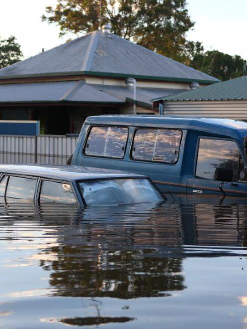 Cars float in a flooded street in Bundaberg.  (Photo by Chris Hyde/Getty Images)
