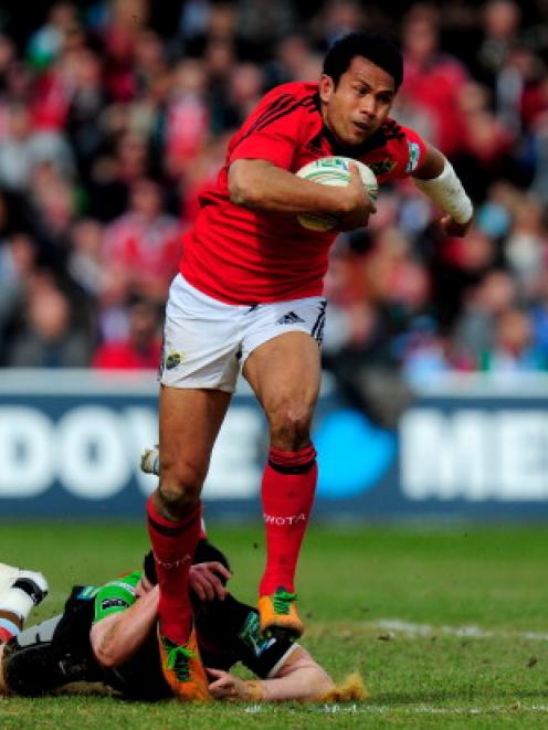 Casey Laulala of Munster goes through the tackle from Tom Casson of Quins during the Heineken Cup...