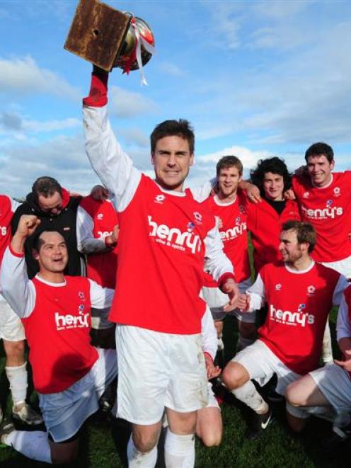 Caversham captain Tim Horner (with trophy) and team-mates celebrate winning the Footballsouth...