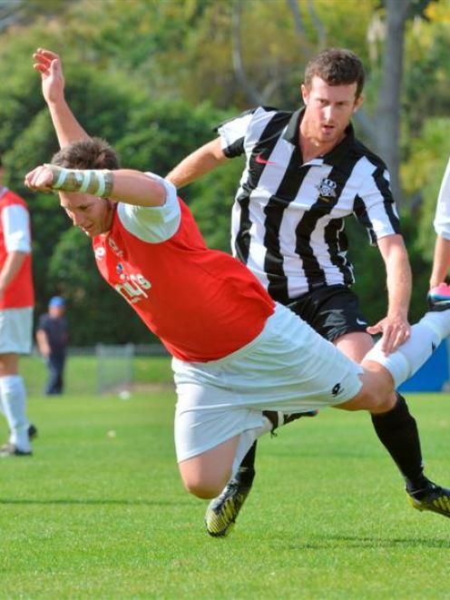 Caversham's Ant Hancock  falls in the challenge of Northern's Mike Scott during a Footballsouth...