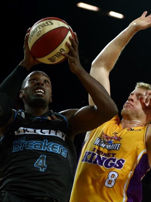 Cedric Jackson of the Breakers drives to the basket under pressure from Josh Duinker of the Kings...