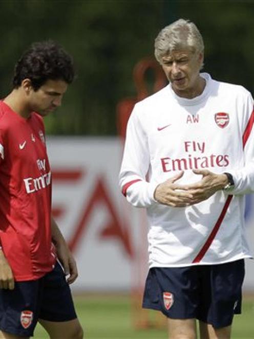 Cesc Fabregas, left, talks to Arsenal manager Arsene Wenger at a recent training session in...