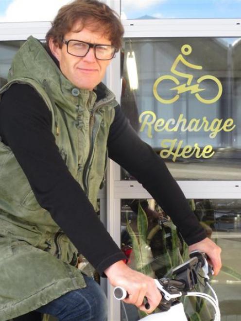 Charge About director Campbell Read with one of his eBikes at a charging station. Photo supplied.