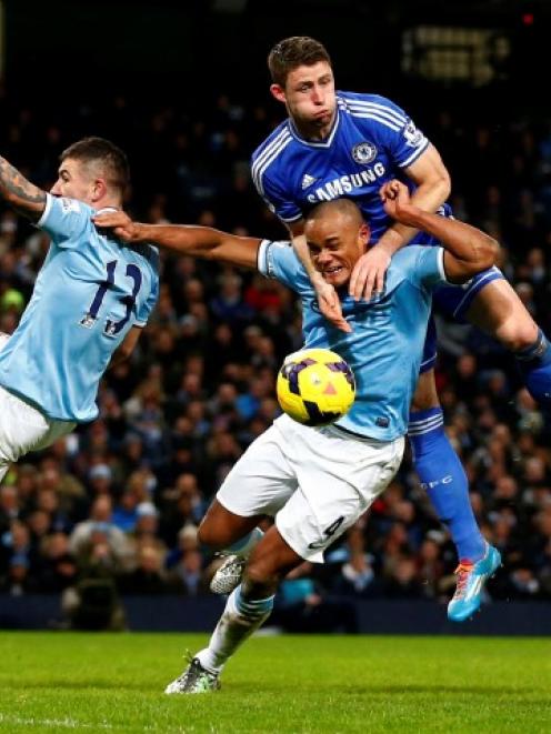 Chelsea's Gary Cahill (C) challenges Manchester City's Vincent Kompany. REUTERS/Darren Staples