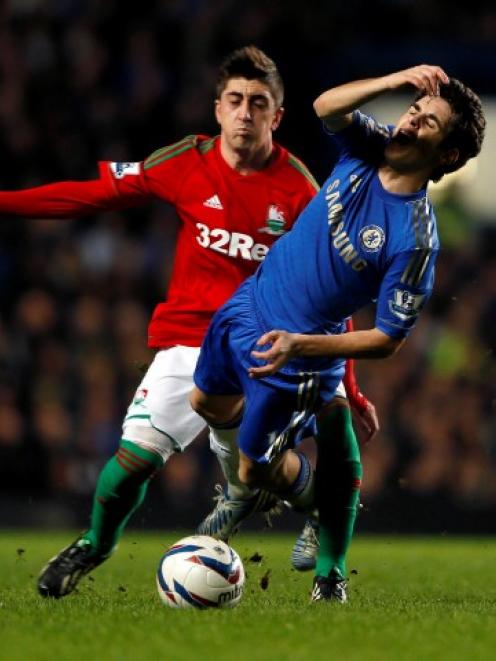 Chelsea's Oscar (front) is challenged by Swansea City's Pablo Hernandez during their English...