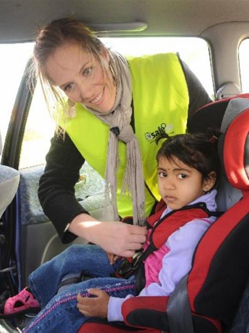 Child restraint technician Mandy Fisher adjusts the restraint on Namrata Chand (4), at the...