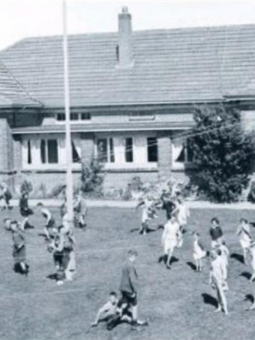 Children at play outside one of the three Glendining cottages in Andersons Bay in November 1950.
...