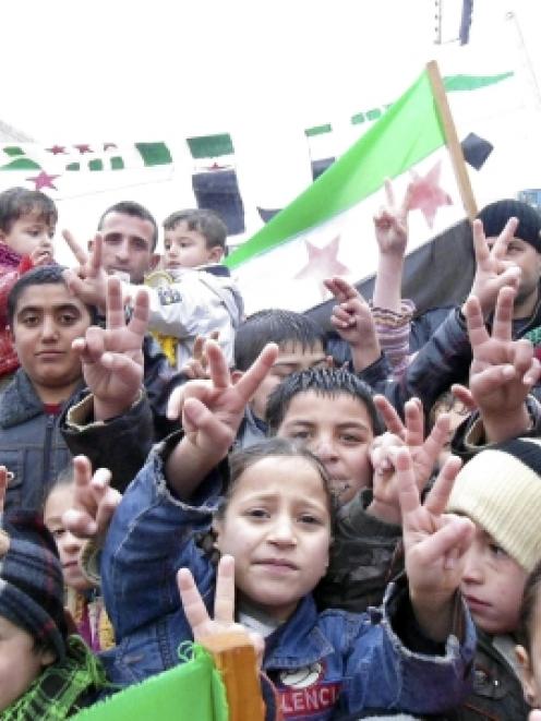 Children flash victory signs during a rally against Syria's President Bashar al-Assad in Jerjenaz...